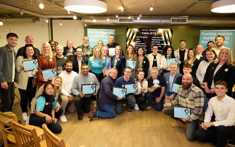 Thirty-seven of the Mates in Mind 2025 Impact Award winners, finalists, guests and staff standing or kneeling in a semi-circle.